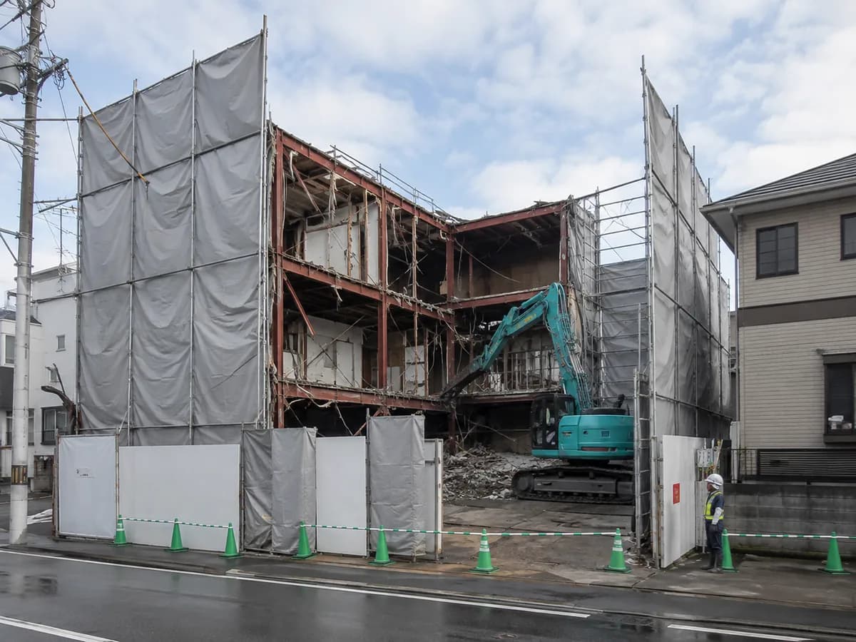 養生シートで囲われた解体工事の現場と重機