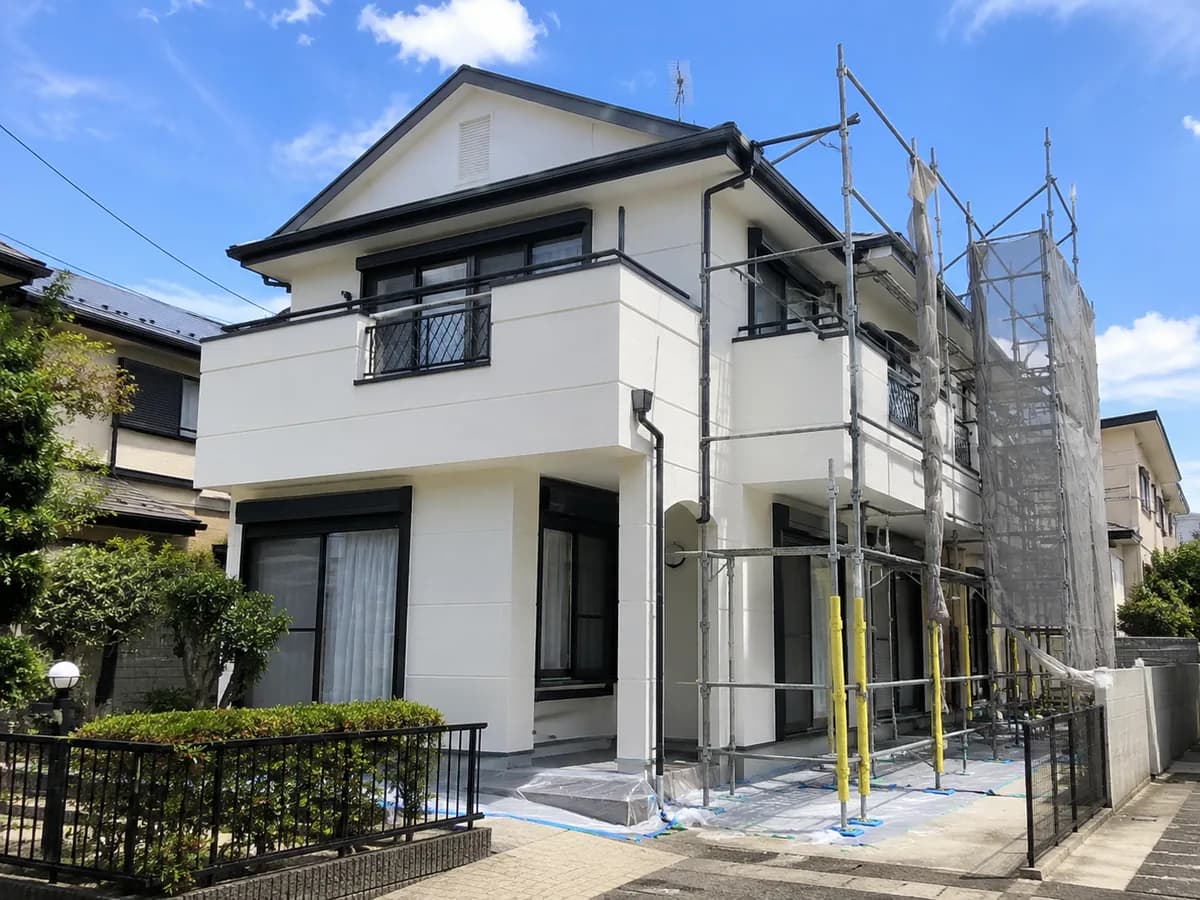 塗り替えを終えた2階建て住宅と、まだ残る足場