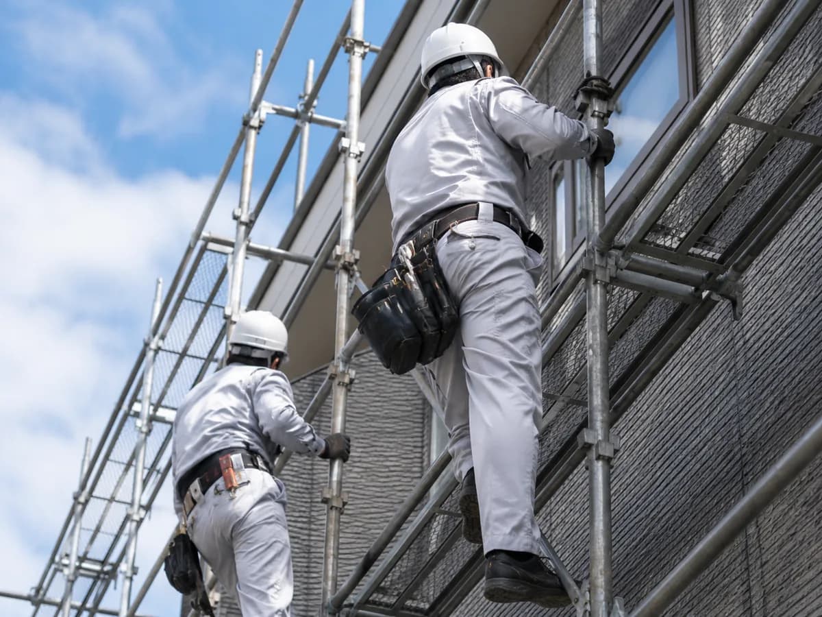 足場を登っていく2人の職人